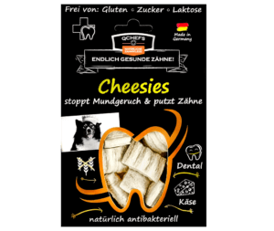 Verpackung der QCHEFS Cheesies für Hunde – natürliche antibakterielle Zahnpflege. Schwarze Verpackung mit gelber Schrift, die beschreibt: „Cheesies stoppen Mundgeruch und putzen Zähne“. Sichtfenster in Zahnform zeigt weiße, käsige Snacks. Frei von Gluten, Zucker und Laktose, hergestellt in Deutschland. Unterstützt die Zahngesundheit von Hunden durch natürliche Inhaltsstoffe.